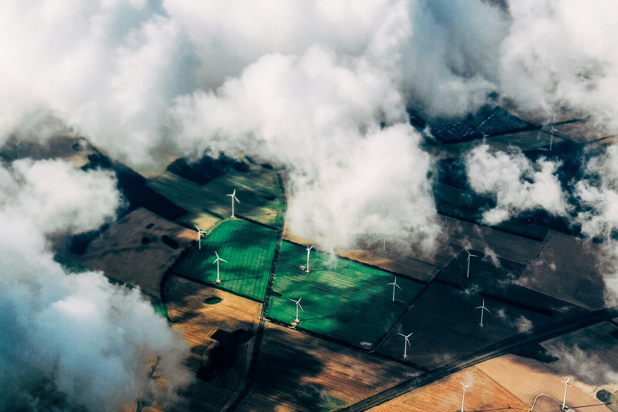 Aerial view of a wind farm with one turbine flagged for possible blade damage and a closer pass requested